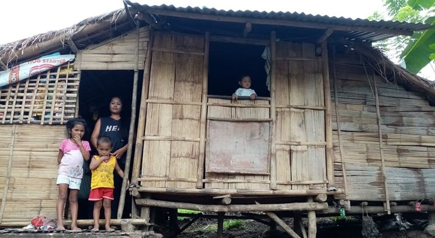Mother and her children in a traditional nipa hut