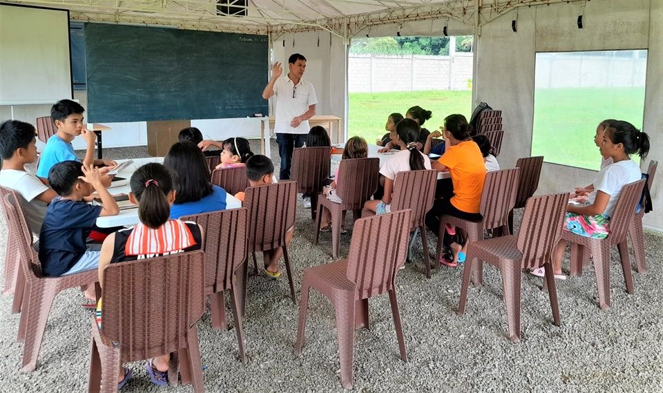 Volunteer teacher Brother Dennis Bello with the CEA children