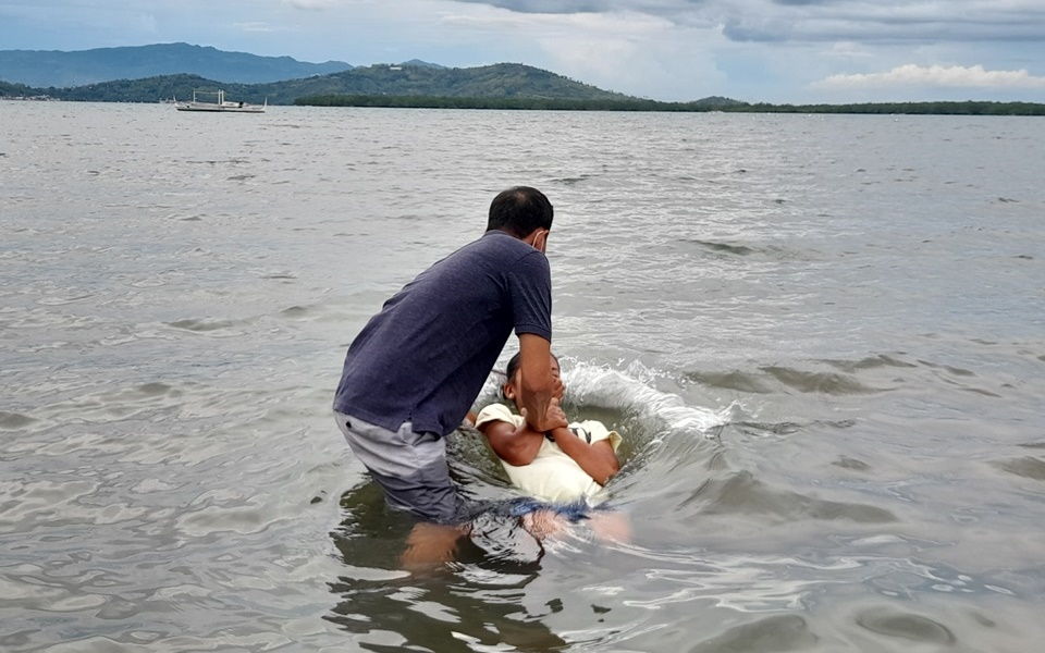 Dennis Bello baptizing a resident 2