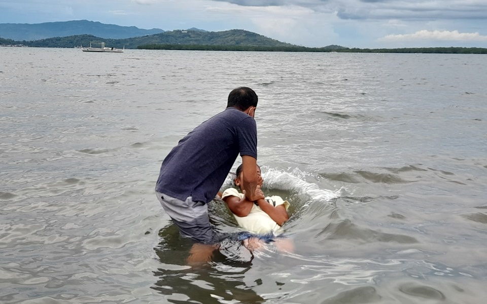 Dennis Bello baptizing a resident 2