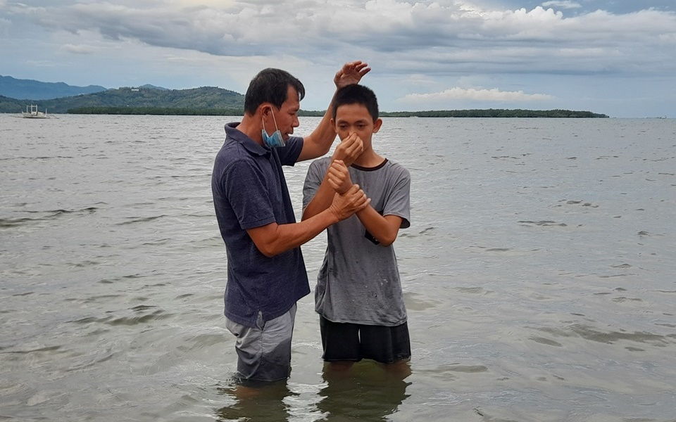 Dennis Bello baptizing a resident
